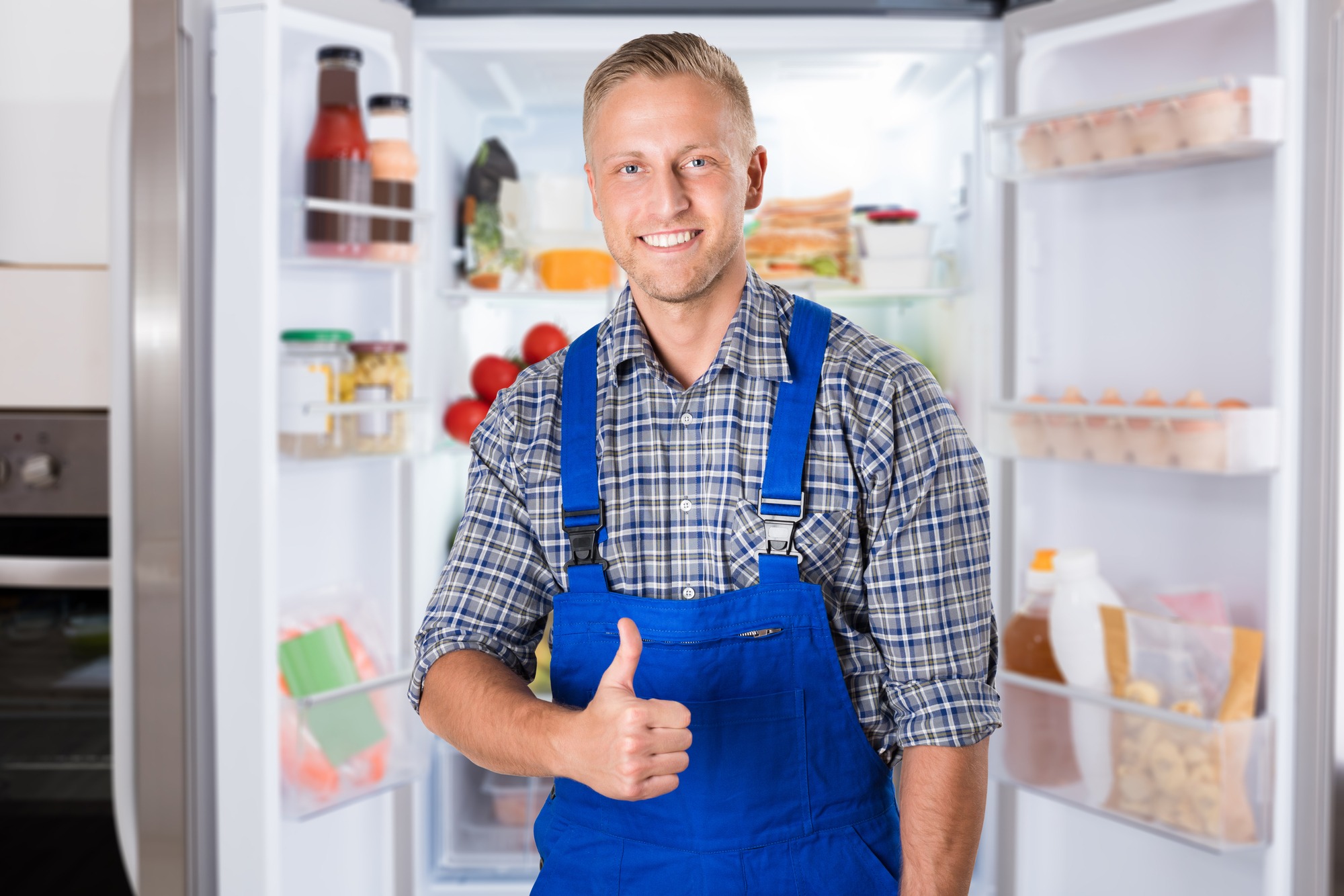 A man stands in front of an open refrigerator